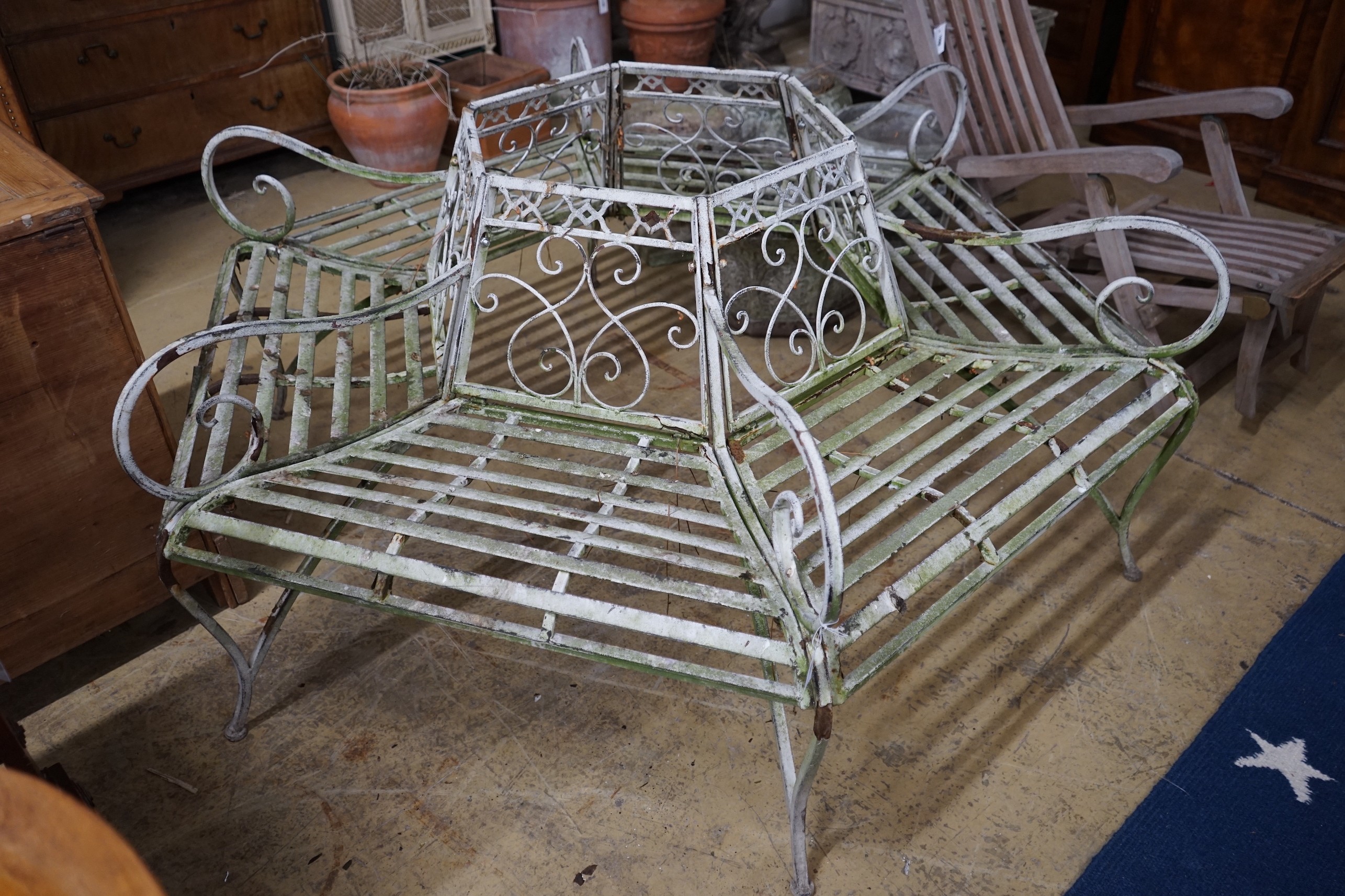 A painted wrought iron hexgonal tree seat, length 150cm, height 77cm
